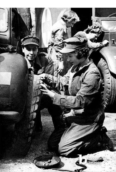 La giovane principessa Elisabetta, futura regina Elisabetta II, impara a cambiare una ruota nel campo di addestramento durante la guerra, 1945 circa (foto bn)  Bridgeman Images 
